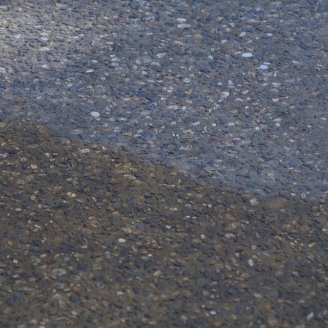 Un jet haute pression nettoie la saleté sur une dalle en béton.