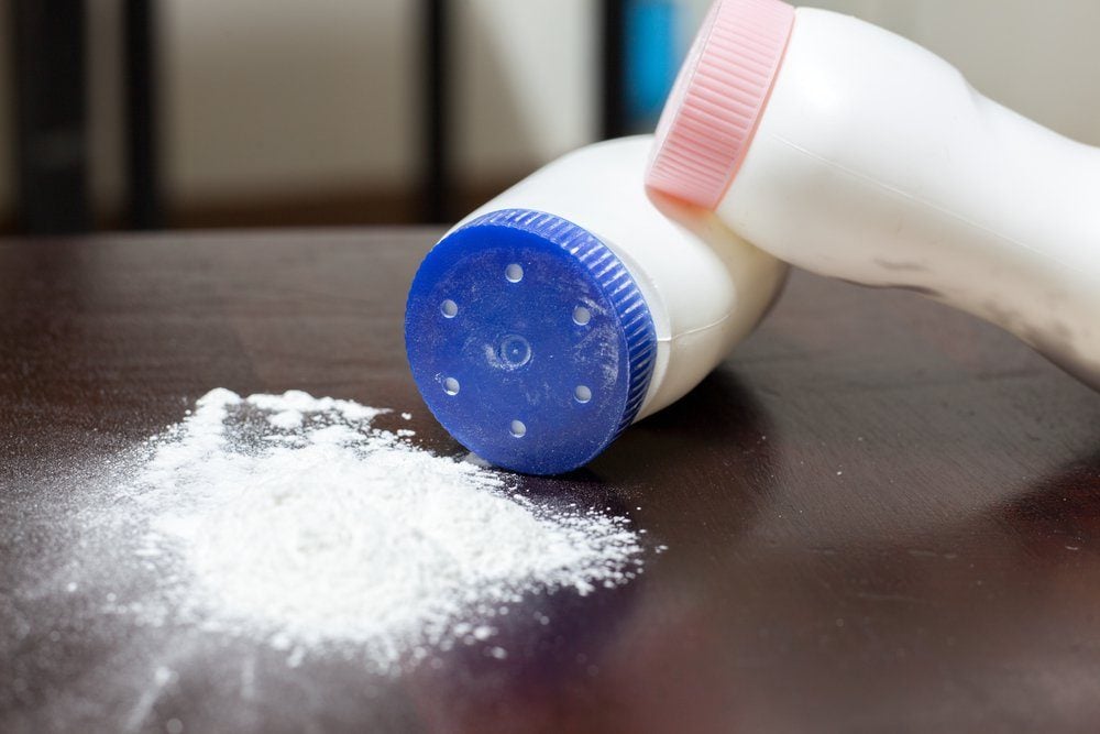 Deux bouteilles de talc renversées sur une surface en bois.