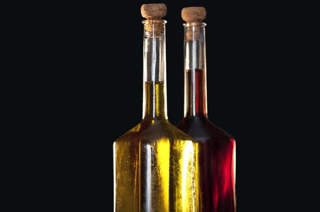 Deux bouteilles en verre avec du vinaigre de différentes couleurs.
