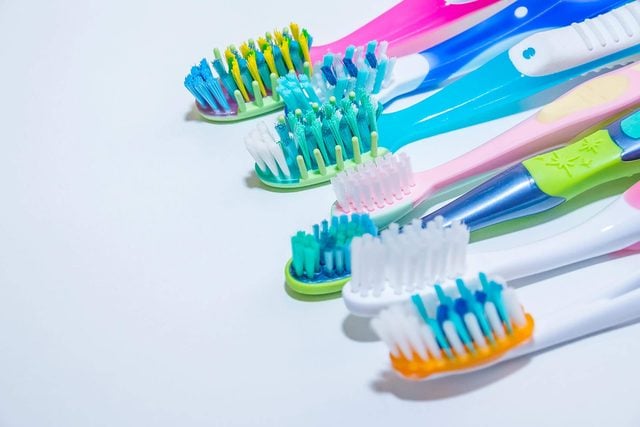 Plusieurs brosses à dents colorées alignées.