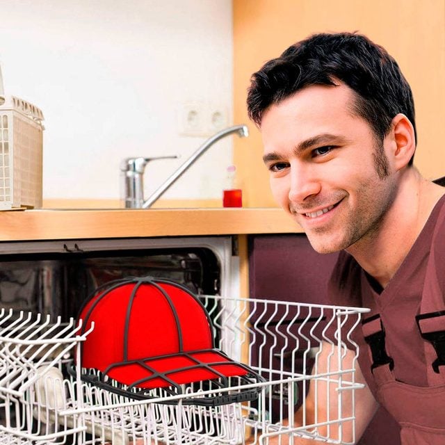 Un homme place une casquette dans un support de lavage avant de la mettre au lave-vaisselle.