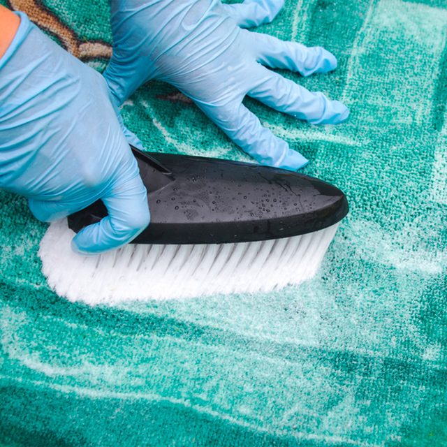 Une personne frotte un tapis