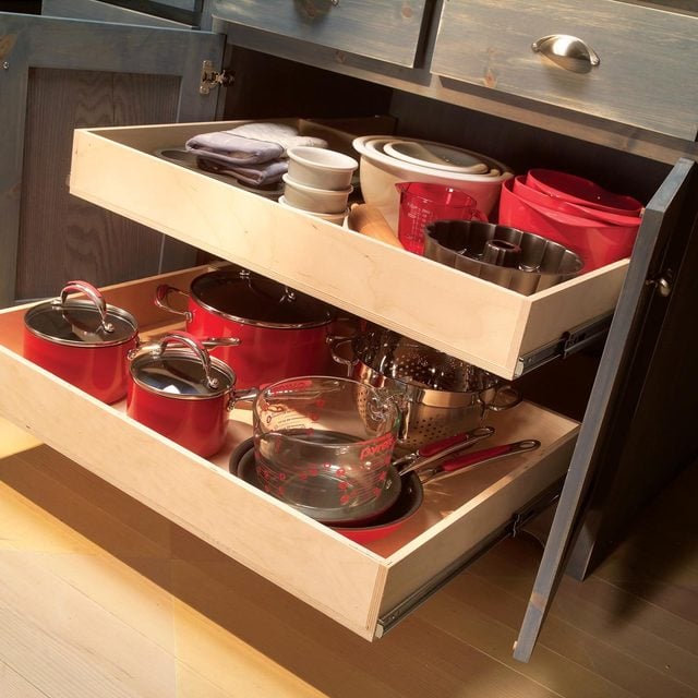 Deux tiroirs de cuisine ouverts montrant des casseroles, des poêles et des ustensiles de cuisine bien rangés.