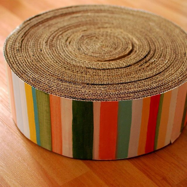 Un griffoir pour chat fait de bandes de carton enroulées.