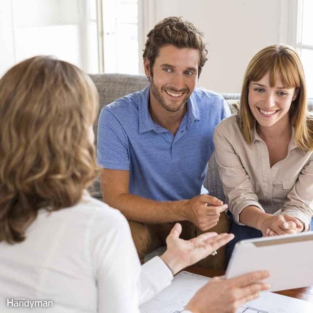 Un agent immobilier présente une maison à un couple.