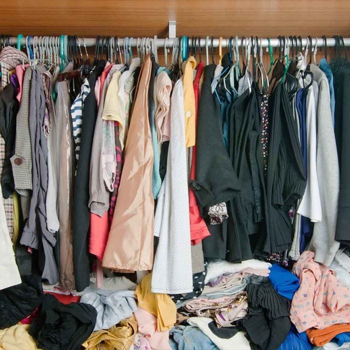 Des vêtements bien pliés et d'autres en désordre sur le sol.