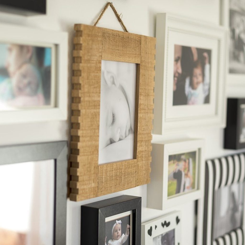 Un mur de cadres avec des photos de famille.