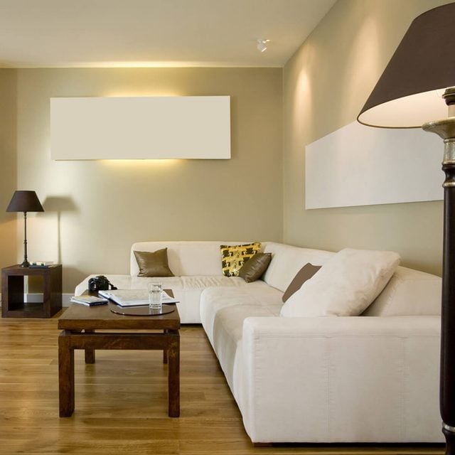 Un salon simple et épuré avec un canapé blanc et une table basse en bois.