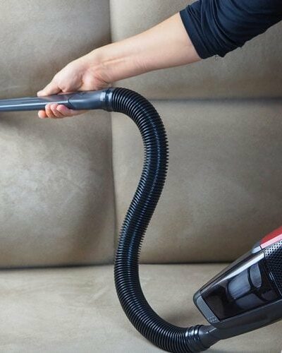 femme passant l'aspirateur sur un canapé