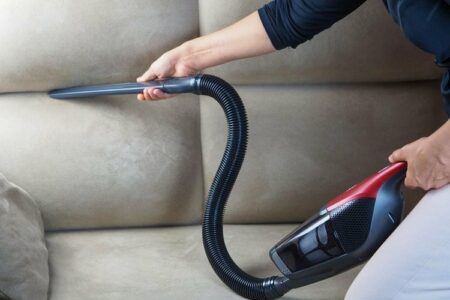 femme passant l'aspirateur sur un canapé