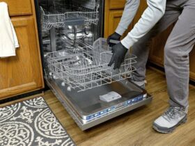 Une personne retire le panier inférieur d'un lave-vaisselle.
