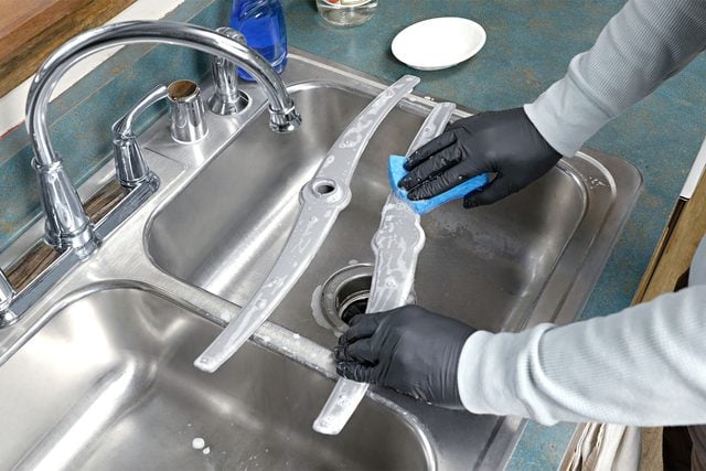 Une personne frotte un bras de lavage avec une éponge savonneuse.