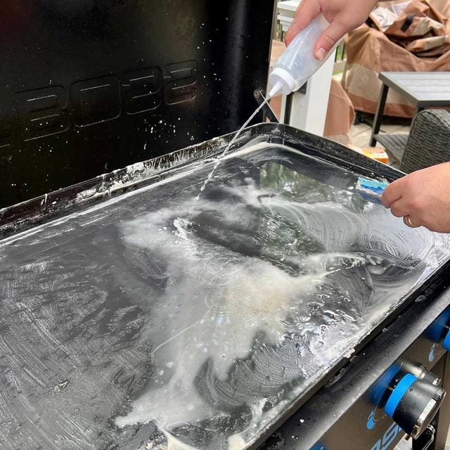 Rinçage de la plaque de cuisson après le nettoyage.
