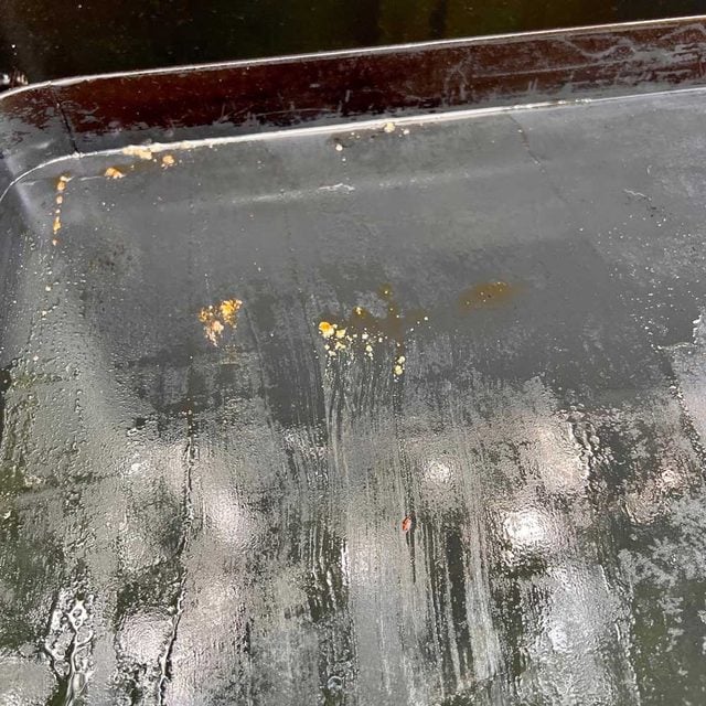 De l'eau versée sur une plancha chaude pour décoller les résidus.