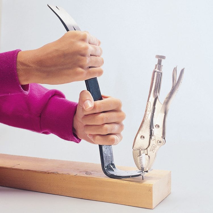 Une pince-étau et un pied-de-biche sont utilisés ensemble pour arracher un clou tenace.