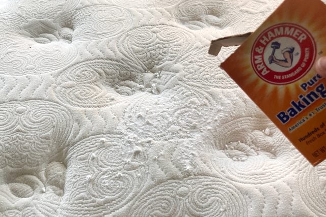 Du bicarbonate de soude versé sur la surface d'un matelas blanc.