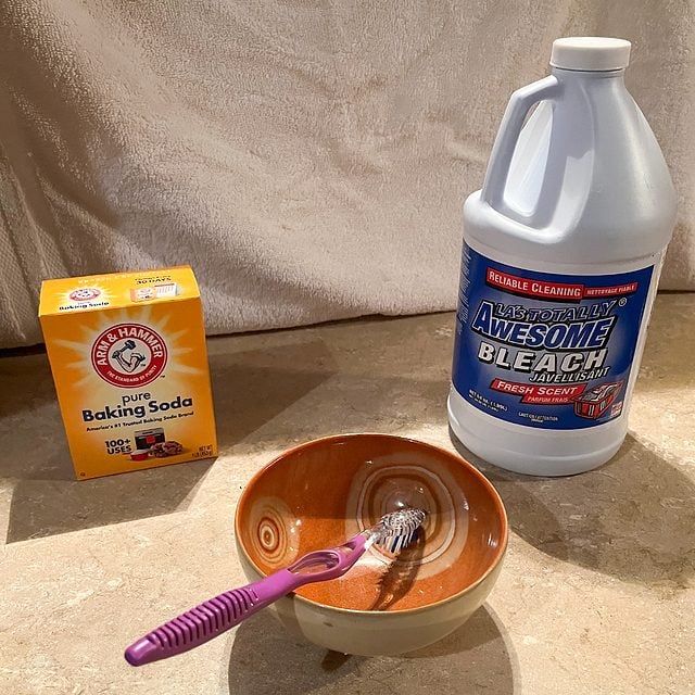 Une bouteille d'eau de Javel et une boîte de bicarbonate de soude.