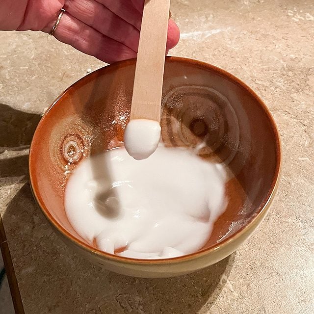 Mélange de bicarbonate de soude et d'eau de Javel dans un bol pour former une pâte.