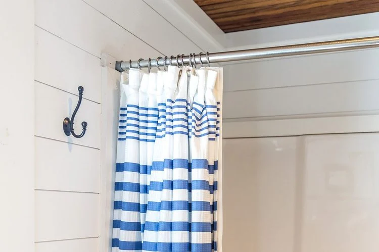 rideau de douche à rayures bleues dans une petite salle de bain