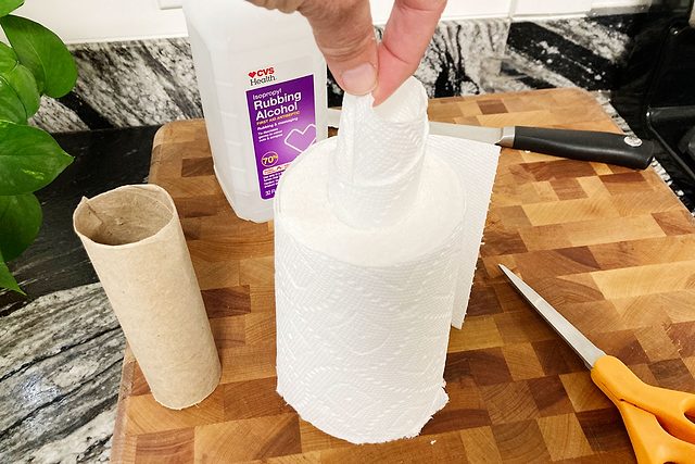 Une main tire la première feuille du centre d'un rouleau d'essuie-tout.