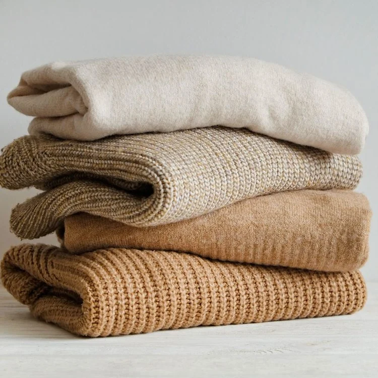 Une pile de pulls en laine et en cachemire pliés.