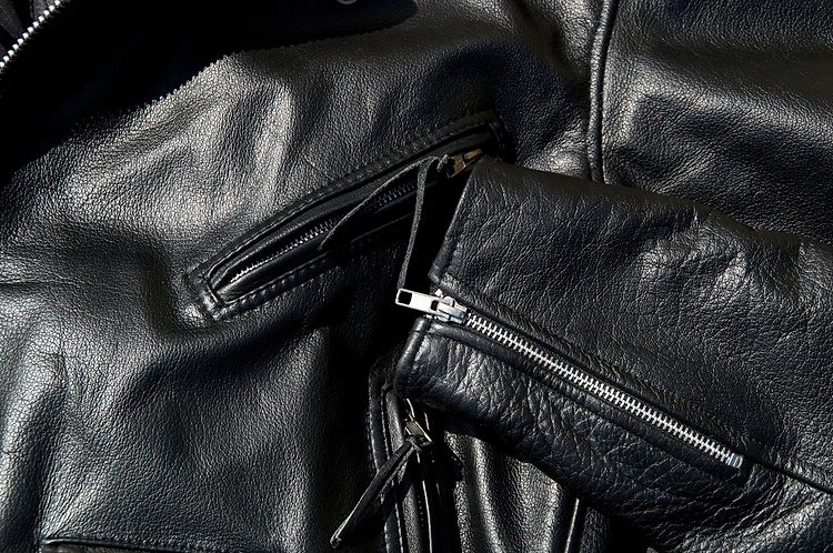 Une veste en cuir noir posée à plat.