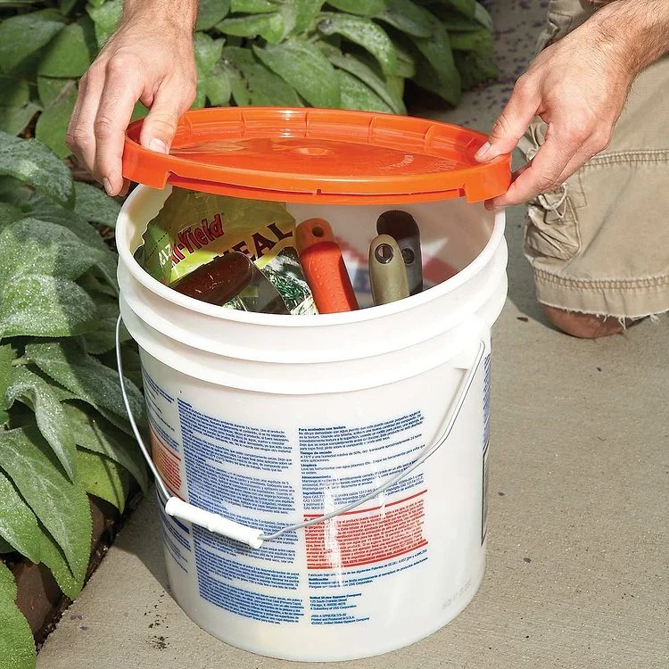 Un seau de chantier rempli d'outils de jardinage.